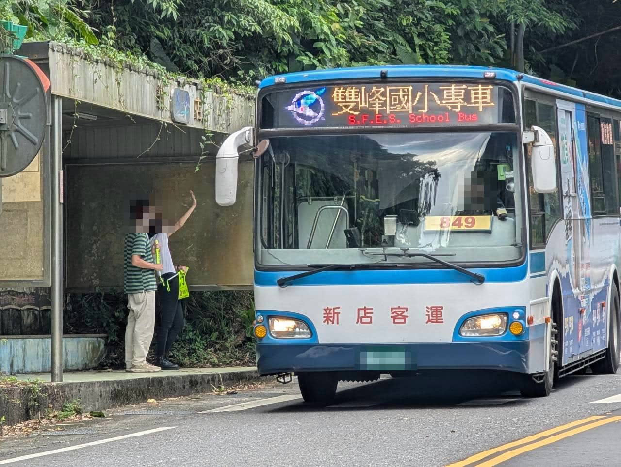 活動照片：雙峰國小專車進站，志工在站牌前揮手引導