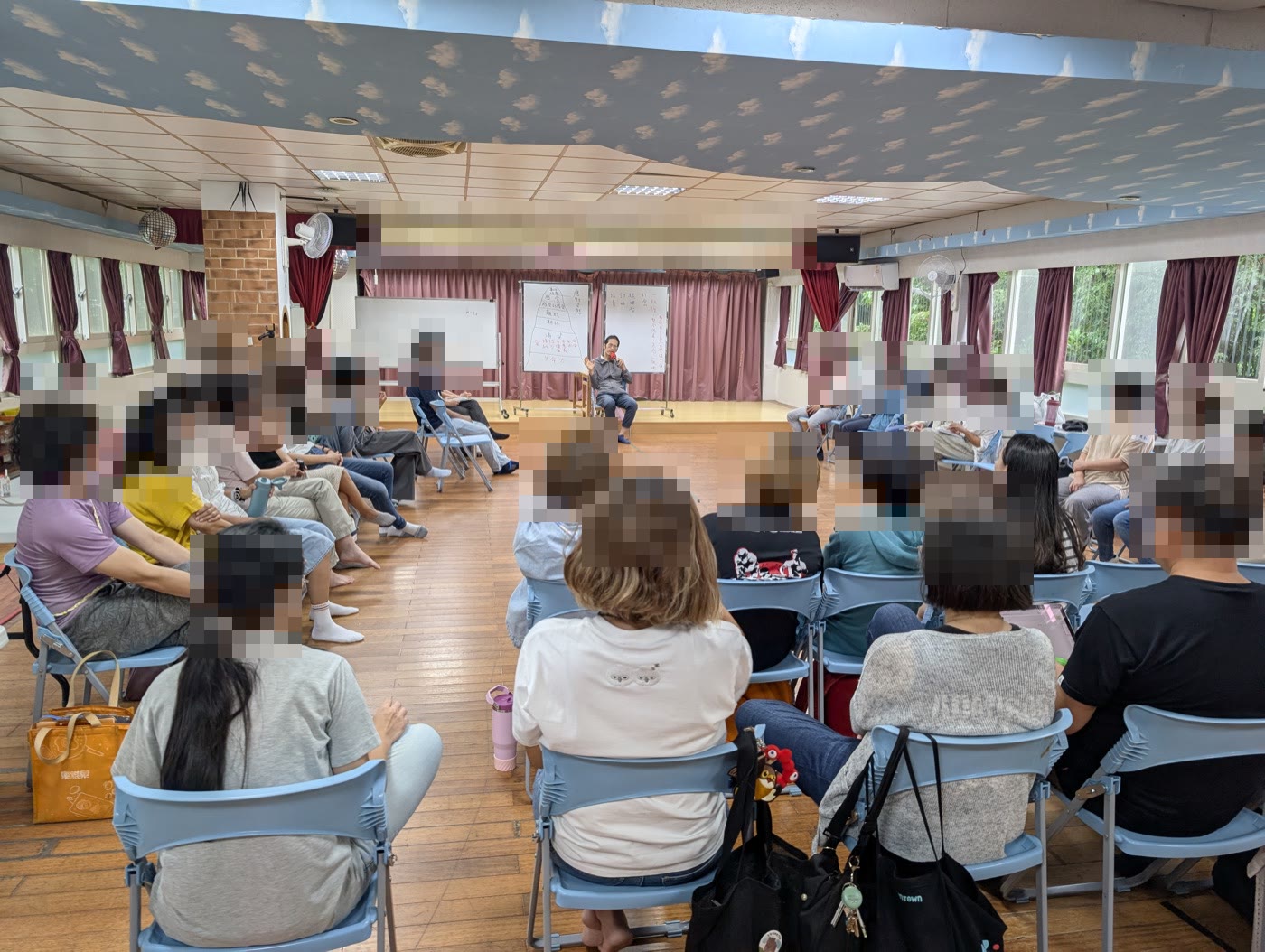 活動照片：老師與家長圍坐在多功能教室，聽講師講解冰山圖